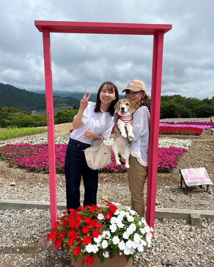 旅行中、記念撮影するメグと末吉さん・娘さん